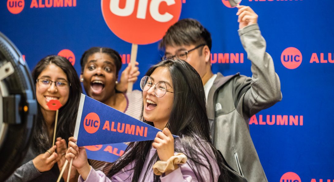 Grad Fest attendees posing in front of UIC Alumni step-and-repeat screen